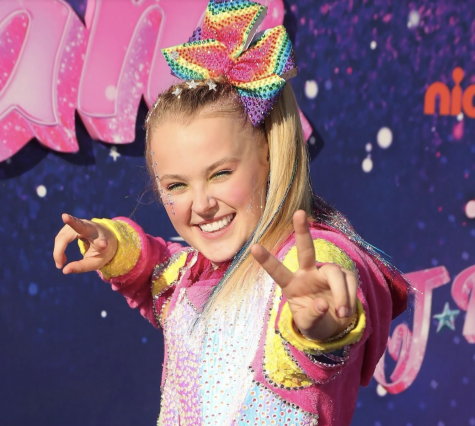 Jojo Siwa makes peace signs in front of the camera. Photo courtesy of Getty Images.