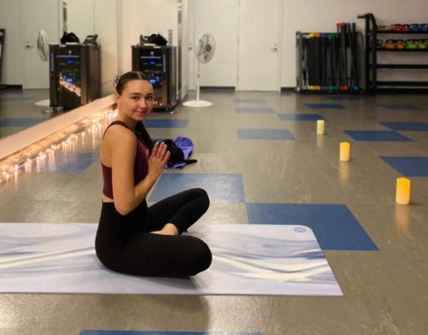 Shiloh Clow sits on her yoga mat in one of Harper’s studios at the fitness center. 
(Photo by Lydia Schultz)