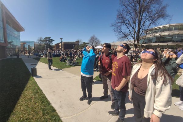 Heads up! Panoramic shot of the eclipse viewing party and its wide range of attendees. (Photo by Cole Altmayer)