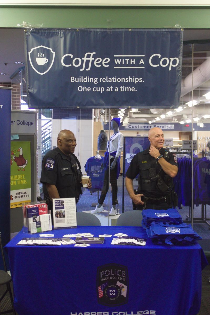 Officer Eddie Jackson and Deputy Chief of Police, Michael Gicla, talk to a student off camera at Coffee With a Cop event on October 1st, 2025. (Photo by Kaylin Prouza)