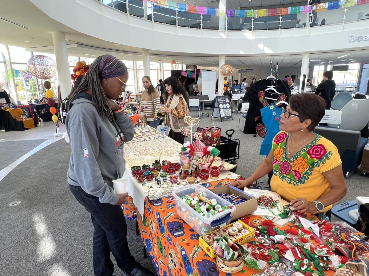 A student looks at a vendors table at the Day of the Dead Celebration on October 29th, 2025. (Photo by Hector Rodriguez)