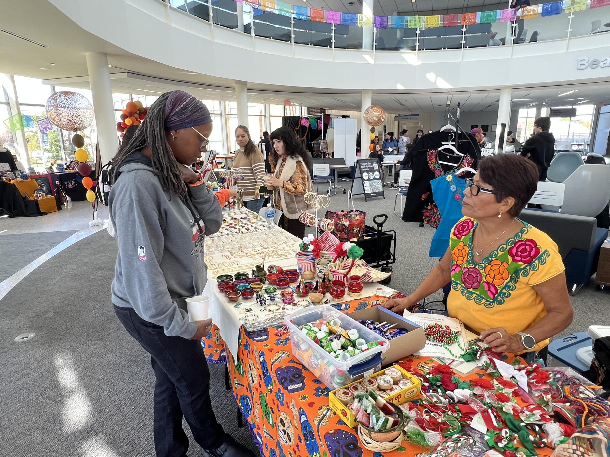 A student looks at a vendors table at the Day of the Dead Celebration on October 29th, 2025. (Photo by Hector Rodriguez)